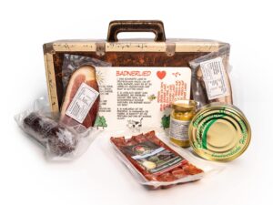 Wurst-Präsentkörbe – Koffer „Badnerlied“ – Geschenkkorb mit Brettchen – Schinken und Salami 7-teilig – Geschenkkorb mit Brotzeitbrett und Badnerlied-Aufdruck