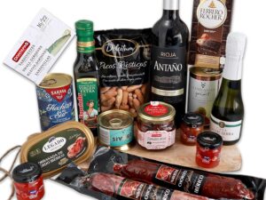 Wein-Präsentkörbe – FAMILYCOM. Gourmet-Geschenkkorb mit originellen Geschenkschokoladen, vielen Würstchen, Konfitüren, einer Auswahl an Weinen und Champagner, Olivenöl und Gourmet-Picks.