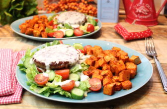 Brotloser Burger auf Salatbett mit Kochkäse und Süßkartoffelwürfeln