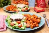 Brotloser Burger auf Salatbett mit Kochkäse und Süßkartoffelwürfeln